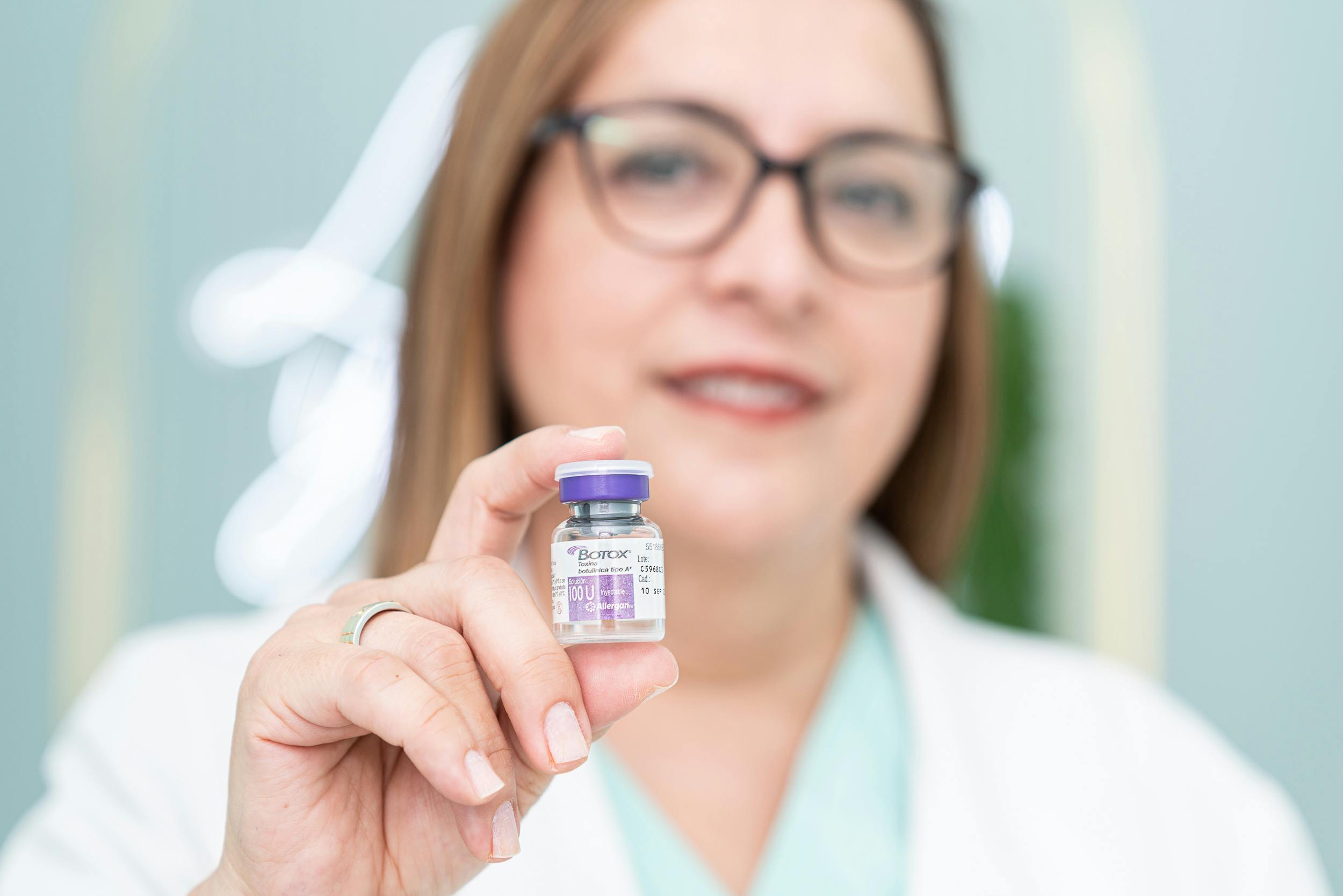 cosmetic doctor holding a Botox vial between her fingers